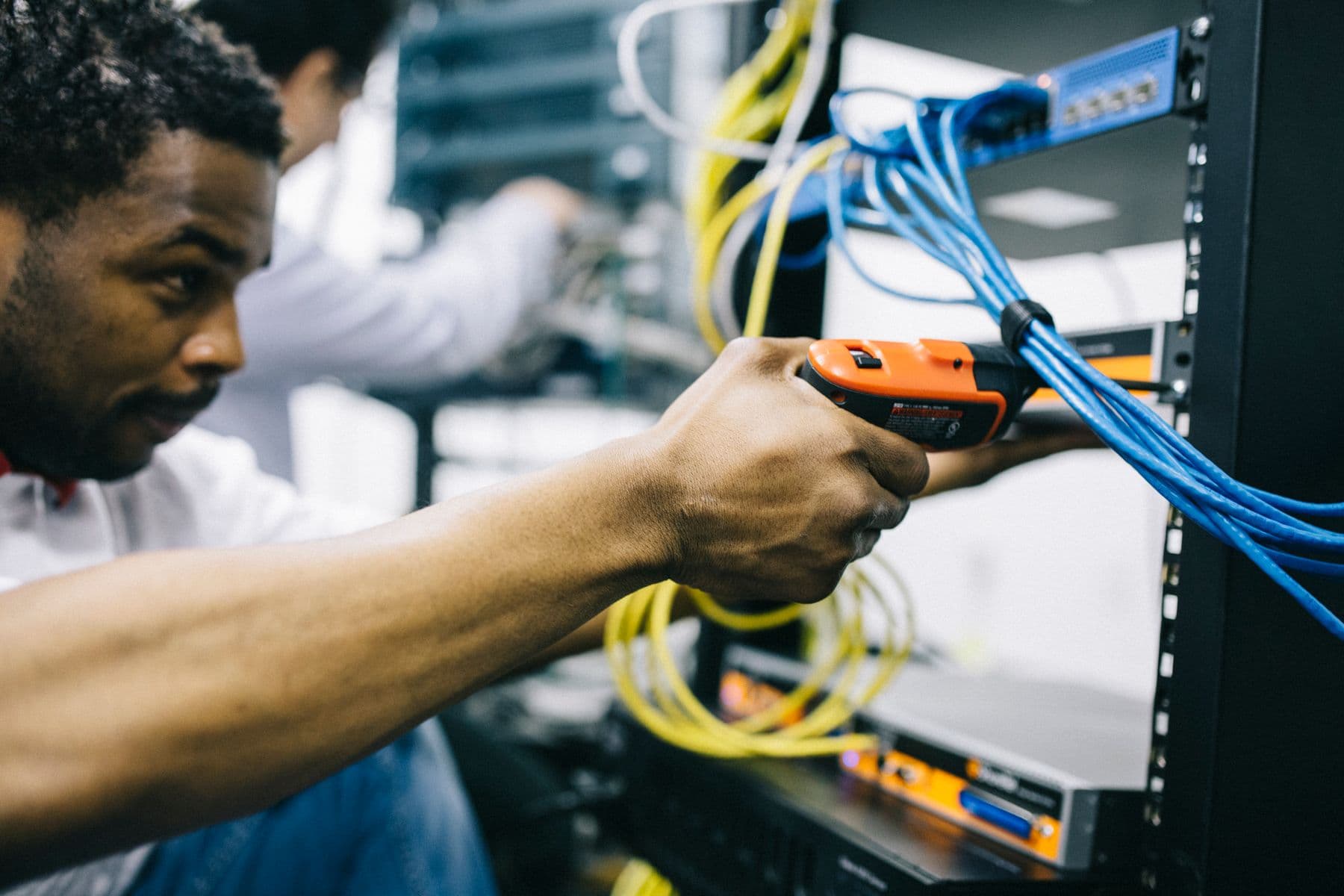 Technician securing network cabling in a commercial equipment rack
